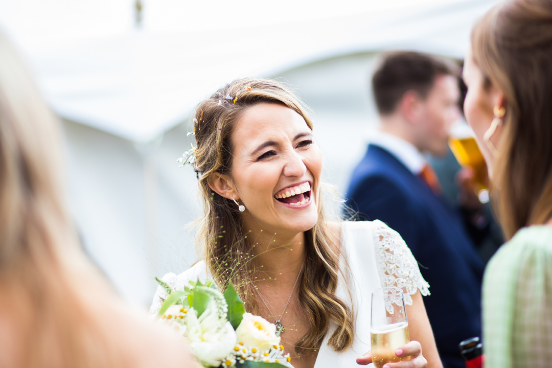 Summer marquee wedding bride laughing